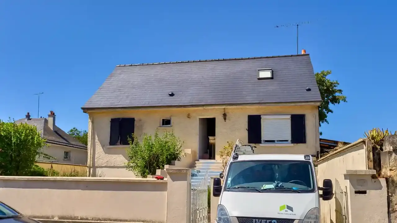Maison avec une toiture en ardoise neuve et une fenêtre de toit, camion de l'entreprise devant