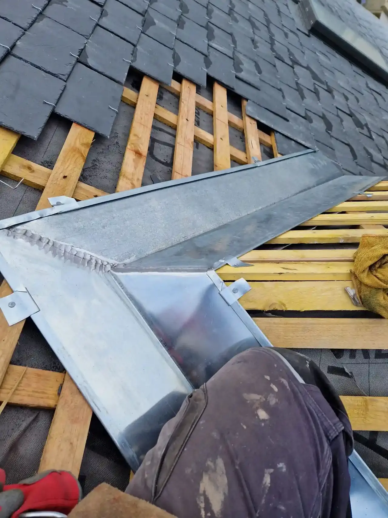 Noue en zinc neuve entre deux pans d'ardoise, posée sur liteaux